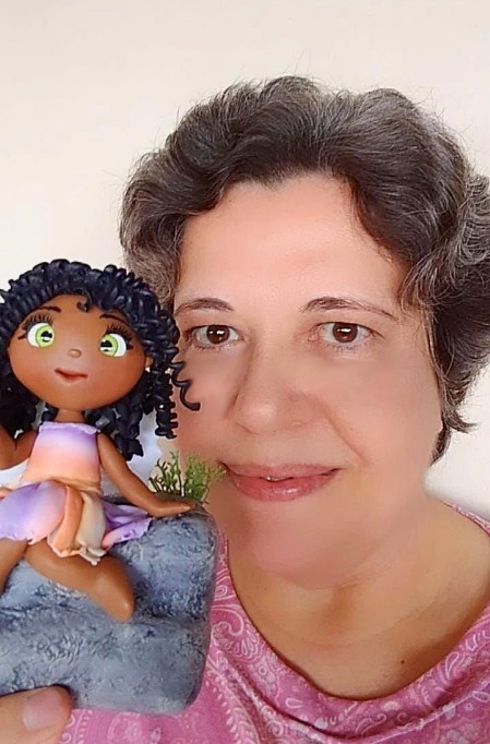 Foto da artesã com um trabalho recente.